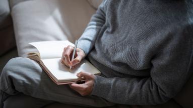 person writing in notebook