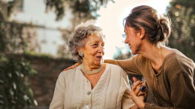Young lady with older lady holding hands