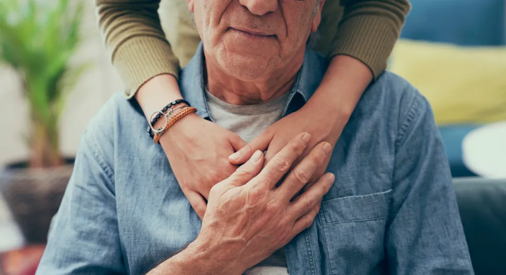 arms gracefully wrapped around a man sitting down