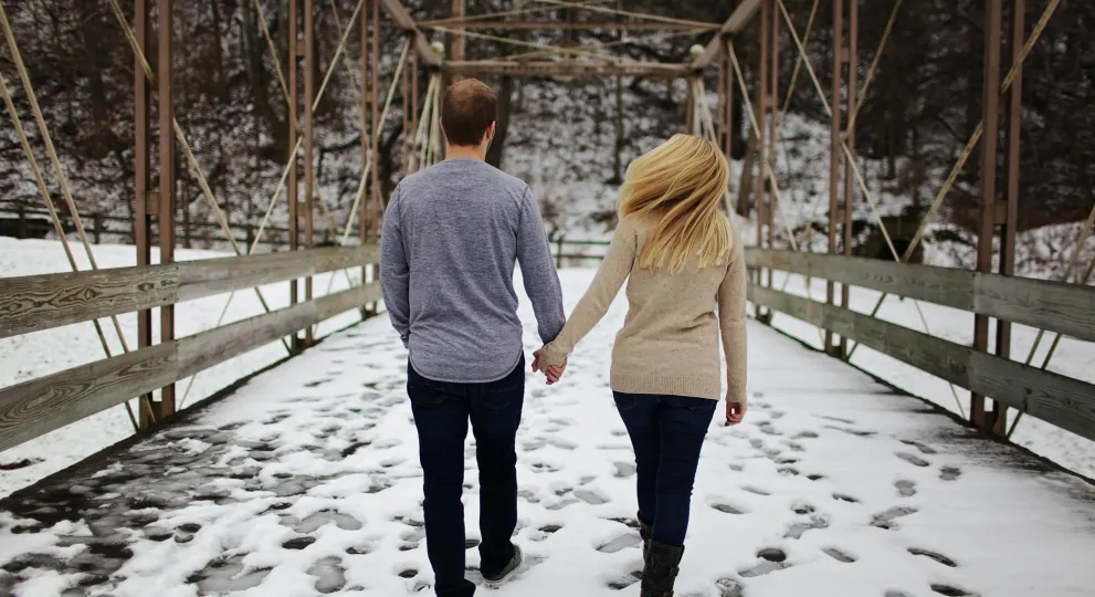 woman and man walking while holdings hand 