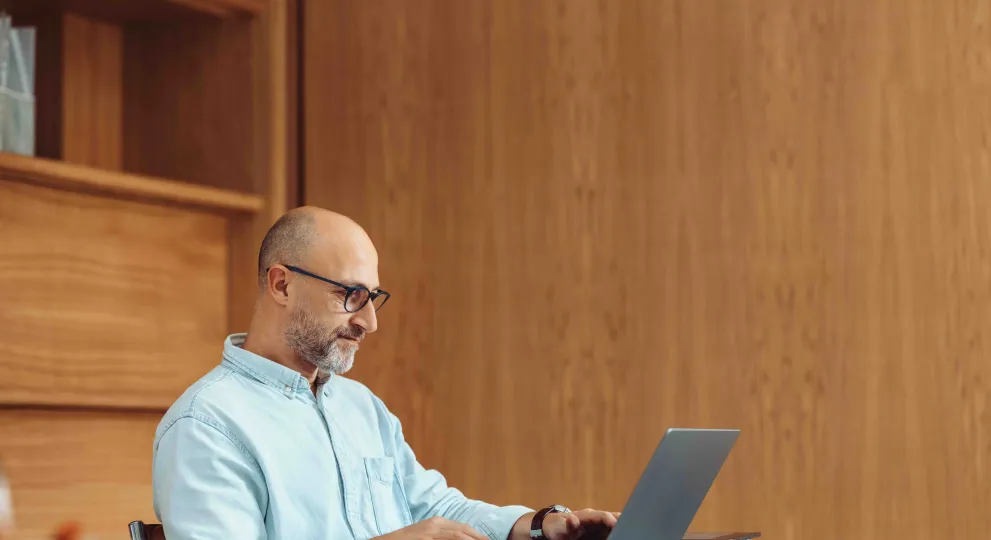 Man sitting at desk using laptop