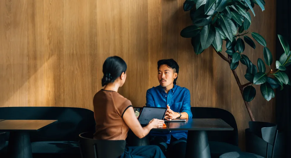 Man sitting across from woman who has laptop in front of her