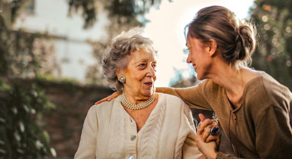 Young lady with older lady holding hands